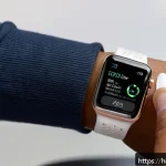 Home 23 애플워치 스트랩 교체 방법 - A close-up, detailed image of a person’s hands carefully removing an Apple Watch silicone strap usin...